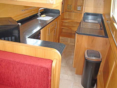 This practical narrowboat galley provides both space in the galley and an arrangement where a dinette or settee can be built into the saloon