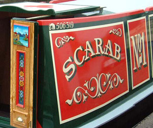 Narrowboat showing traditional decoration on stern doors and signwritten panels